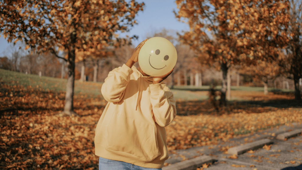 A person holding a smiley face