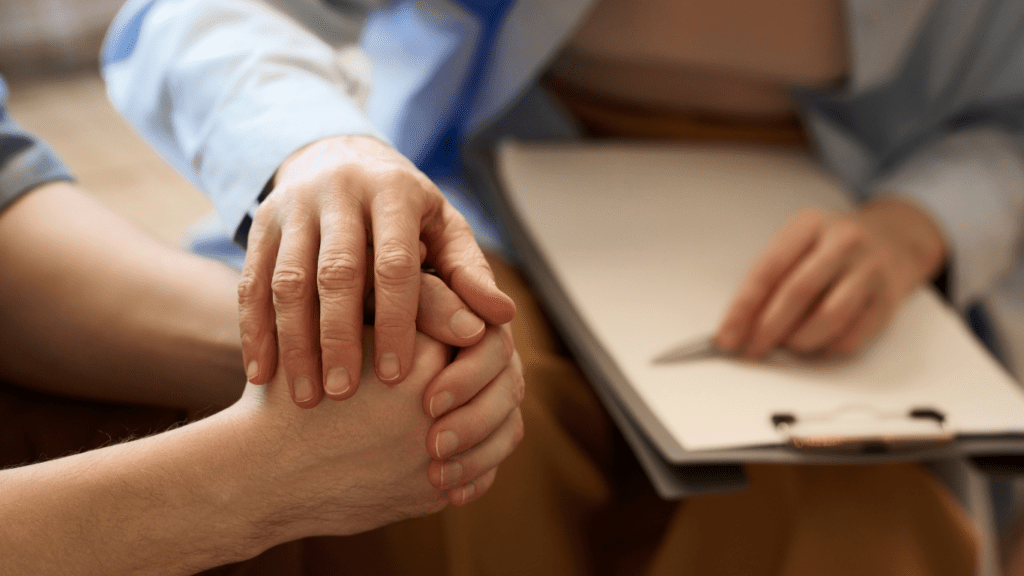 a person holding the hand of another person in front of a clipboard