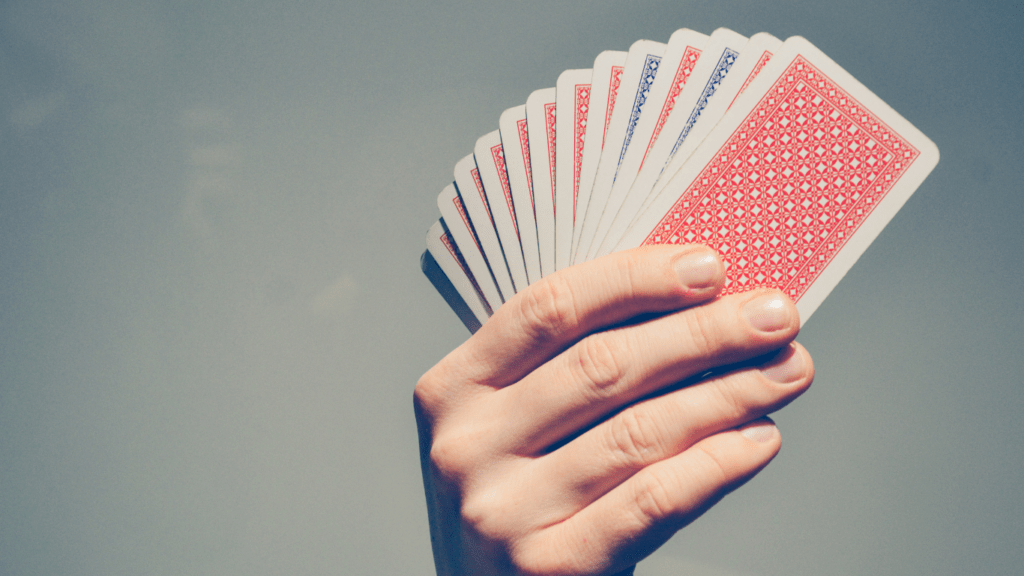 a person holding up a deck of playing cards