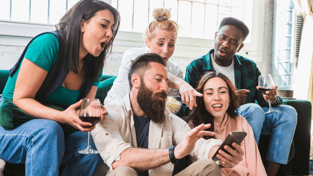 a group of people sitting on a couch looking at a cell phone