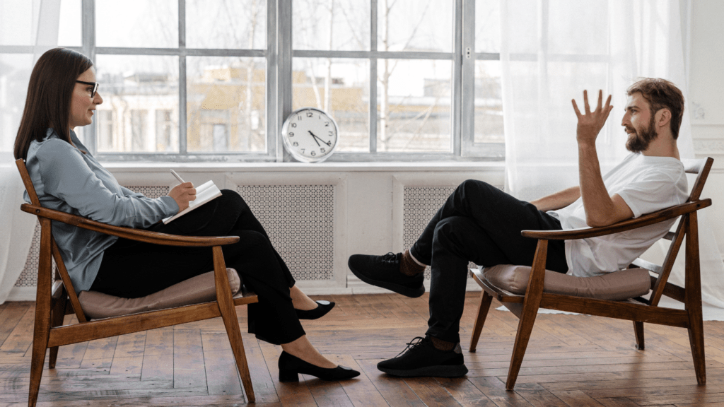 two people sitting on a couch talking to each other