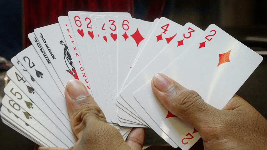 a person holding up a deck of playing cards