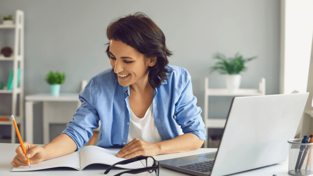 a woman is sitting at a table with a laptop in front of them