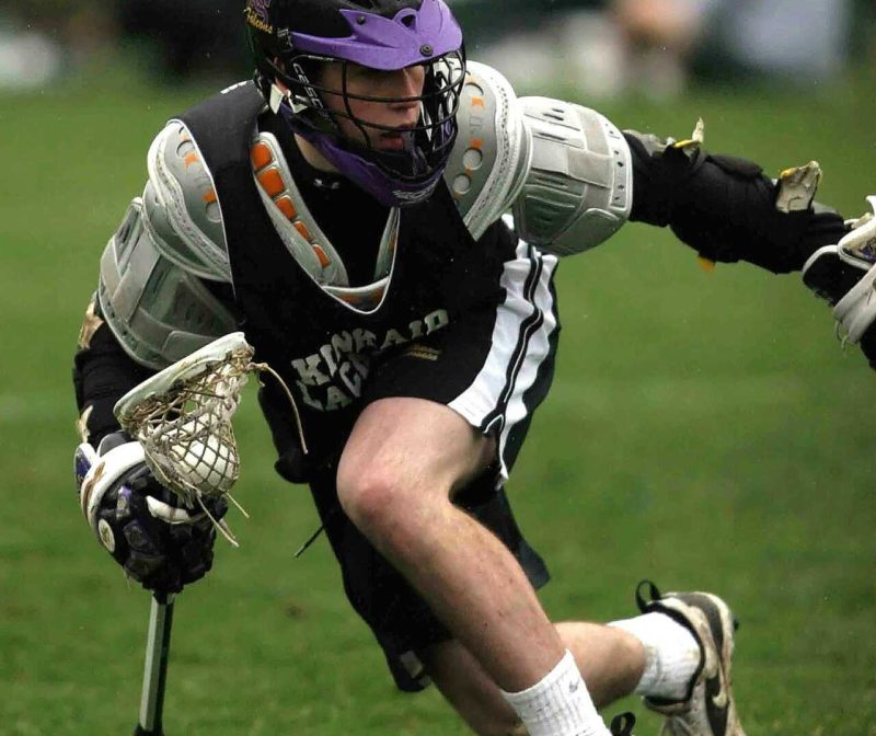 Person in Black Sports Jersey Playing Lacrosse